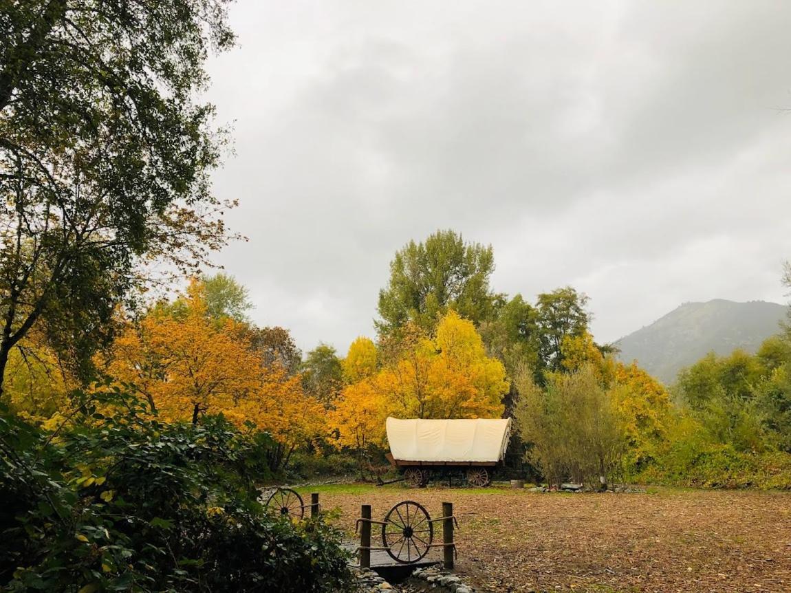 Cozy Wild West Covered Wagon Next To River Luxury tent